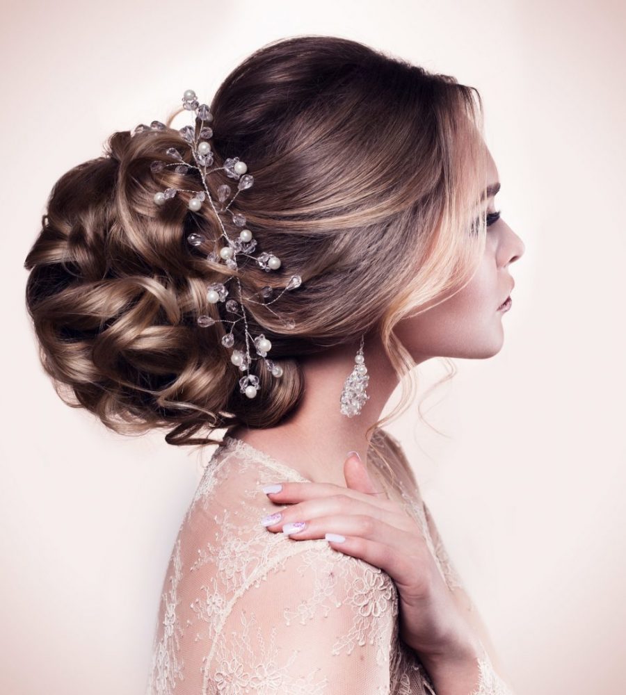 Beautiful bride with fashion wedding hairstyle - on beige background.